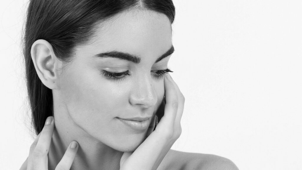 Imagen artística en blanco y negro de mujer con orejas bien posicionadas y contorno facial armonioso, representativa de los resultados de una otoplastia